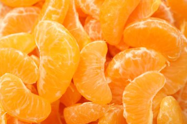 Arka plan olarak birçok olgun soyulmuş mandalina, üst görünüm