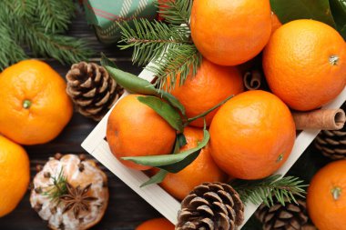 Olgun mandalinalar, baharatlar, köknar ağacı dalları ve koniler masada, düz yatıyordu.