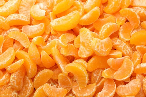 Arka plan olarak birçok olgun soyulmuş mandalina, üst görünüm