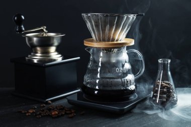 Cam kimya kahve makinesi. Lezzetli kahve, filtre, fasulye, öğütücü ve siyah masaya yakın çekim.