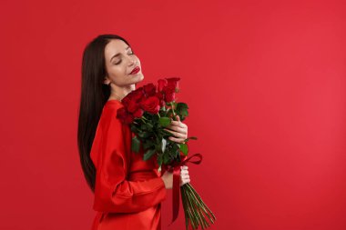 Sevgililer Günü. Kırmızı arka planda gül buketi olan güzel bir kadın. Metin için boşluk