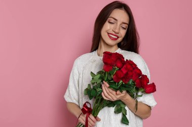 Sevgililer Günü. Pembe arka planda gülleri olan bir kadın. Metin için boşluk