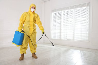 Koruyucu giysiler içinde böcek ilacı sıkan bir haşereci. Metin için boşluk