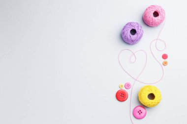 Beyaz arka planda iplik ve düğme topları, düz yatış. Metin için boşluk