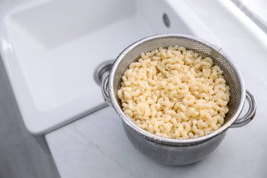 Mutfakta makarna üzerine elek, yakın plan. Metin için boşluk