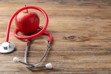Tahta masada olgun elma ve steteskop, yakın plan. Metin için boşluk