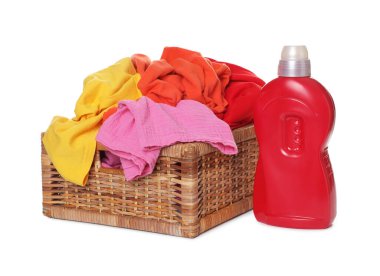 Çamaşır sepetinin içinde giysiler ve beyaza izole edilmiş bir şişe deterjan.