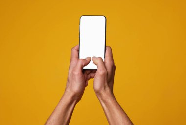 Turuncu arka planda boş ekranlı akıllı telefon tutan adam, yakın plan. Tasarım için model