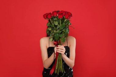 Sevgililer Günü. Kırmızı arka planda gül buketi olan güzel bir kadın.
