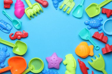 Açık mavi arka planda çocuk plaj oyuncakları çerçevesi, düz yatış. Metin için boşluk