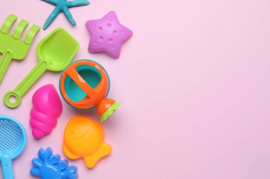 Pembe arka planda çocukların plaj oyuncakları, düz yatış. Metin için boşluk
