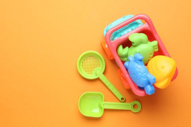 Turuncu arka planda çocukların plaj oyuncakları, düz yatış. Metin için boşluk