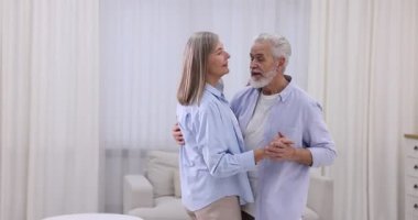 Güzel yaşlı çift evde dans ediyor.