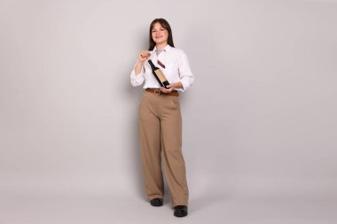 Profesyonel şarap garsonu açık gri arka planda şarap şişesi açıyor.