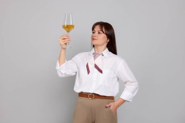 Açık gri arka planda beyaz şarap kadehi olan profesyonel şarap garsonu.