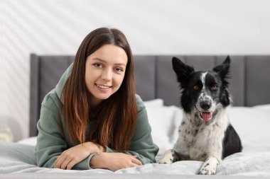 Evde yatağında Collie köpeği olan bir kadın.