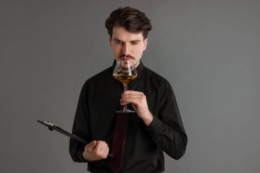 Gri arka planda beyaz şarap ve panosu olan profesyonel şarap garsonu.