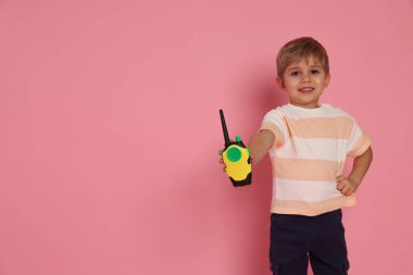 Pembe arka planda radyosu olan gülümseyen küçük çocuk, mesaj için boşluk.