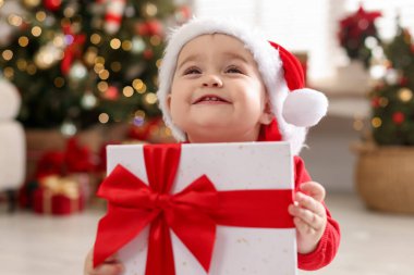 Noel Baba şapkalı şirin bir çocuk ve evde hediyeleri var. Bebeğin ilk Noel 'i