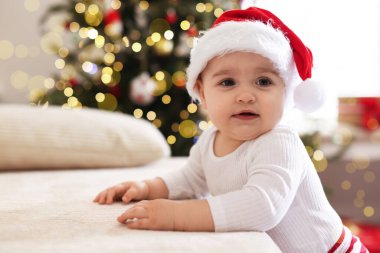 Evdeki koltukta Noel Baba şapkalı şirin küçük çocuk, mesaj atmak için yer var. Bebeğin ilk Noel 'i