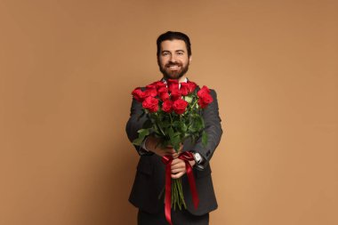Sevgililer Günü. Bej arka planda gül demeti olan bir adam.