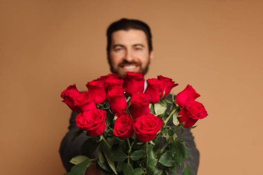 Sevgililer Günü. Bej arka planda gül buketi olan adam, seçici odaklı.