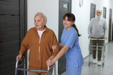 Huzurevinde Walker 'a yardım eden bakım işçisi.