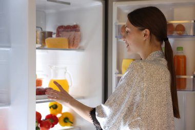 Genç kadının yanına modern mutfak buzdolabında