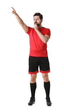 Üniformalı hakem beyaz arka planda düdük çalıyor.