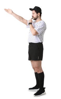 Üniformalı hakem beyaz arka planda düdük çalıyor.