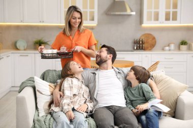 Mutlu aile, evdeki mutfaktaki kanepede birlikte vakit geçiriyor.