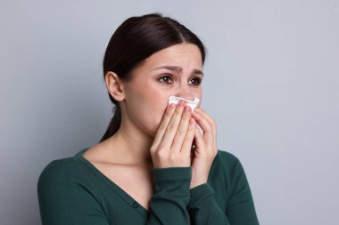 Hafif arka planda burnu akan bir kadın. Soğuk Semptom