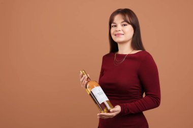 Soluk kahverengi arka planda beyaz şarap şişesi olan profesyonel şarap garsonu.