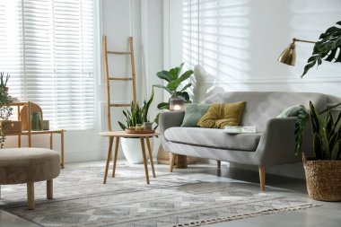 Kanepesi ve çiçekleri olan şık bir oturma odası. İç tasarım