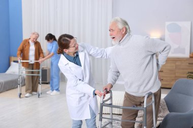 Huzurevinde aylaklara yardım eden bakım işçileri, seçici odaklanma