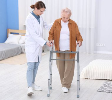 Huzurevinde Walker 'a yardım eden bakım işçisi.