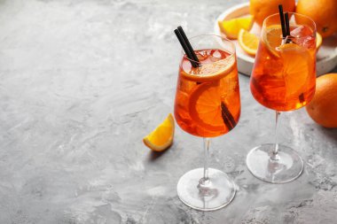Gri desenli masada serinletici spritzer kokteyli ve portakallar. Metin için boşluk