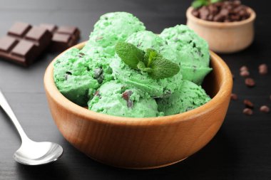 Siyah ahşap masada servis edilen naneli çikolatalı dondurma.