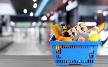 Süpermarketteki ürünlerle dolu bir alışveriş sepeti. Metin için boşluk