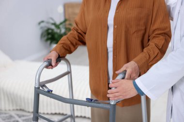 Huzurevinde Walker 'a yardım eden bakım işçisi, yakın plan.