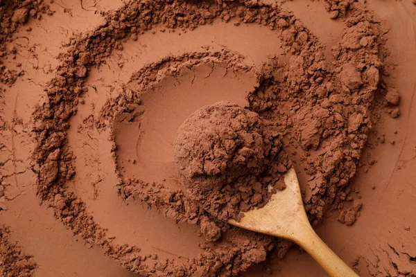 Kakao tozu ve tahta kaşık arka plan olarak, üst görünüm