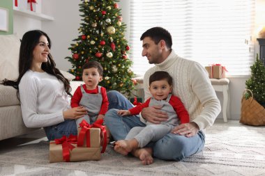 Aileler ve evde Noel hediyeleri olan şirin ikiz bebekler.