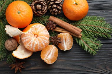 Olgun mandalinalar, baharatlar, ceviz, köknar ağacı dalları ve kozalaklar ahşap masa üzerinde, düz yatıyordu.