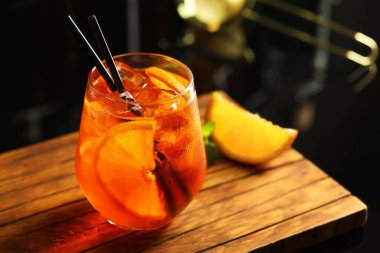 Bardaki ahşap masada taze sodalı kokteyl ve portakal dilimi, yakın plan.