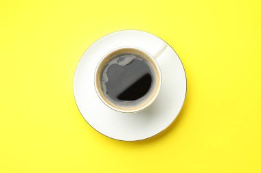 Sarı masada fincanda Aromatik kahve, üst manzara.
