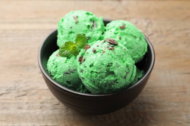 Nefis naneli çikolatalı dondurma kasede, ahşap masada, yakın plan.