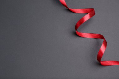 Gri arka planda güzel kırmızı kurdele. Metin için boşluk