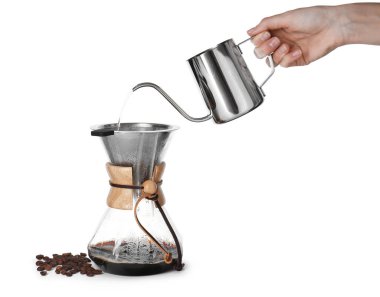 Beyaz arka planda cam kimya kahve makinesine sıcak su döken kadın, yakın plan.