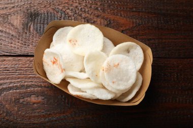 Lezzetli pirinç cipsleri, paket kutusunda, ahşap masada, üst tarafta.