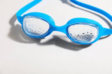 Açık arkaplanda mavi yüzme gözlükleri, yakın plan.